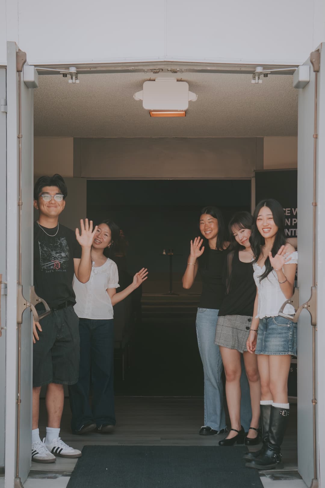 Community members waving at the church doorway