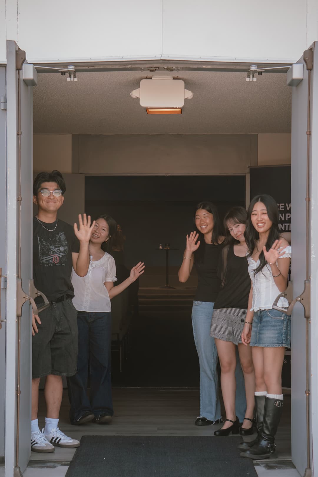 Community members waving at the church doorway