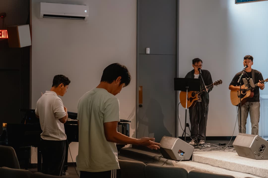Worship band performing with piano and guitars