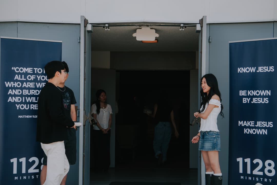 Community members welcoming each other at the church entrance