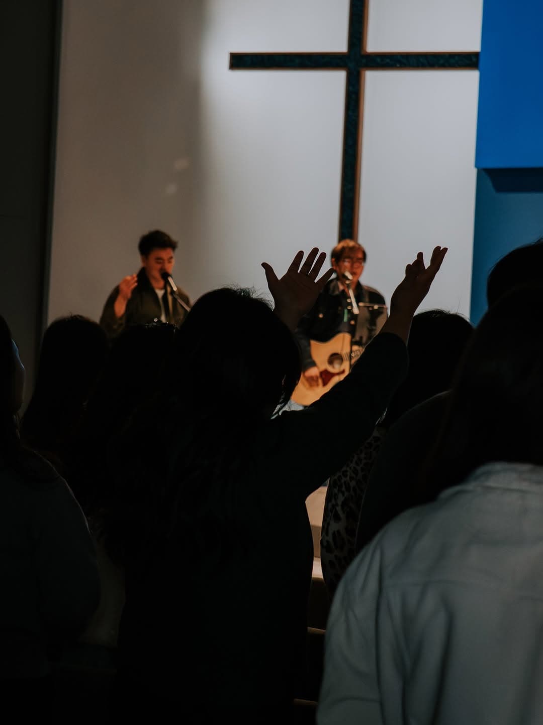 Worship with hand raised toward the cross