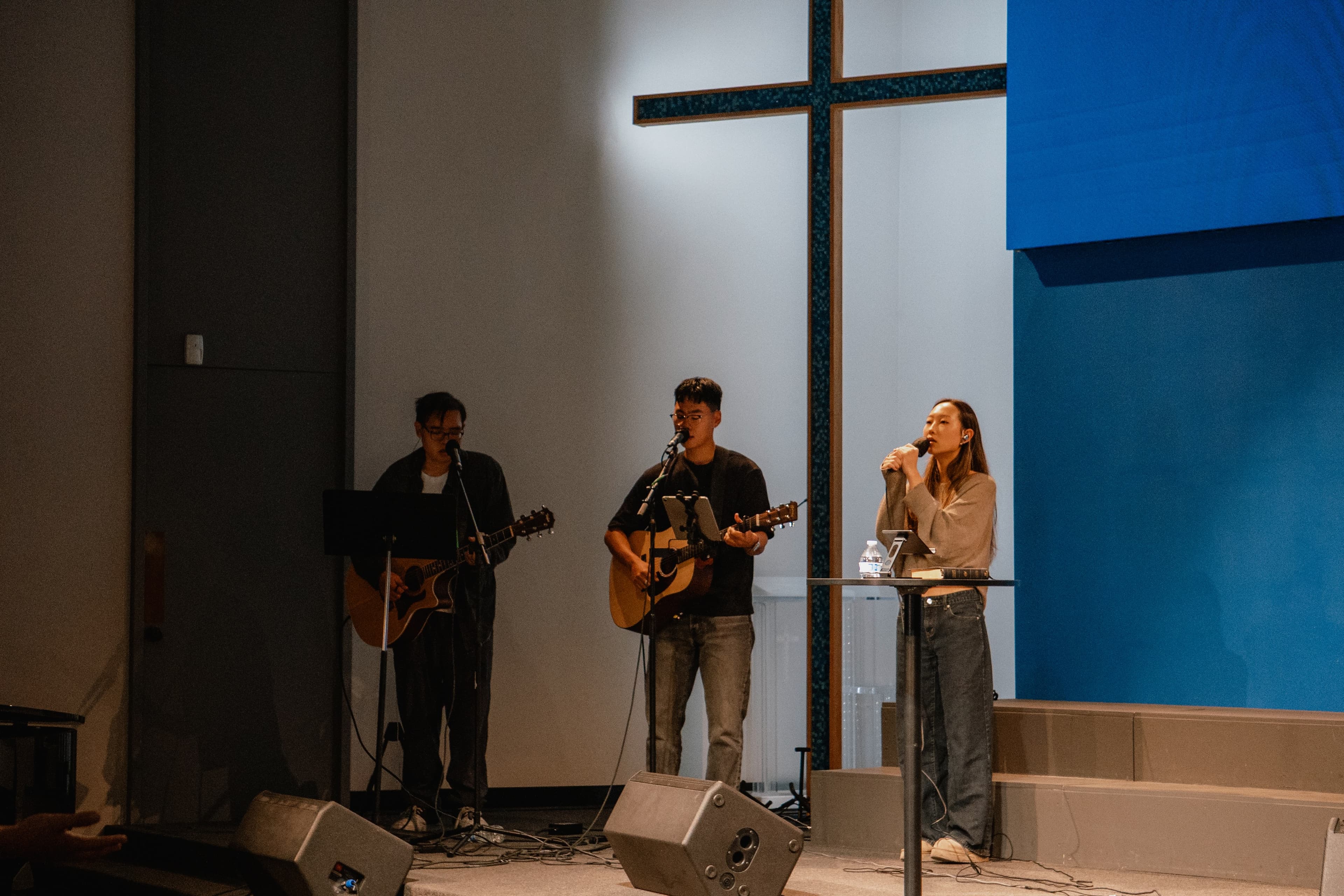 Worship band performing on stage with the cross